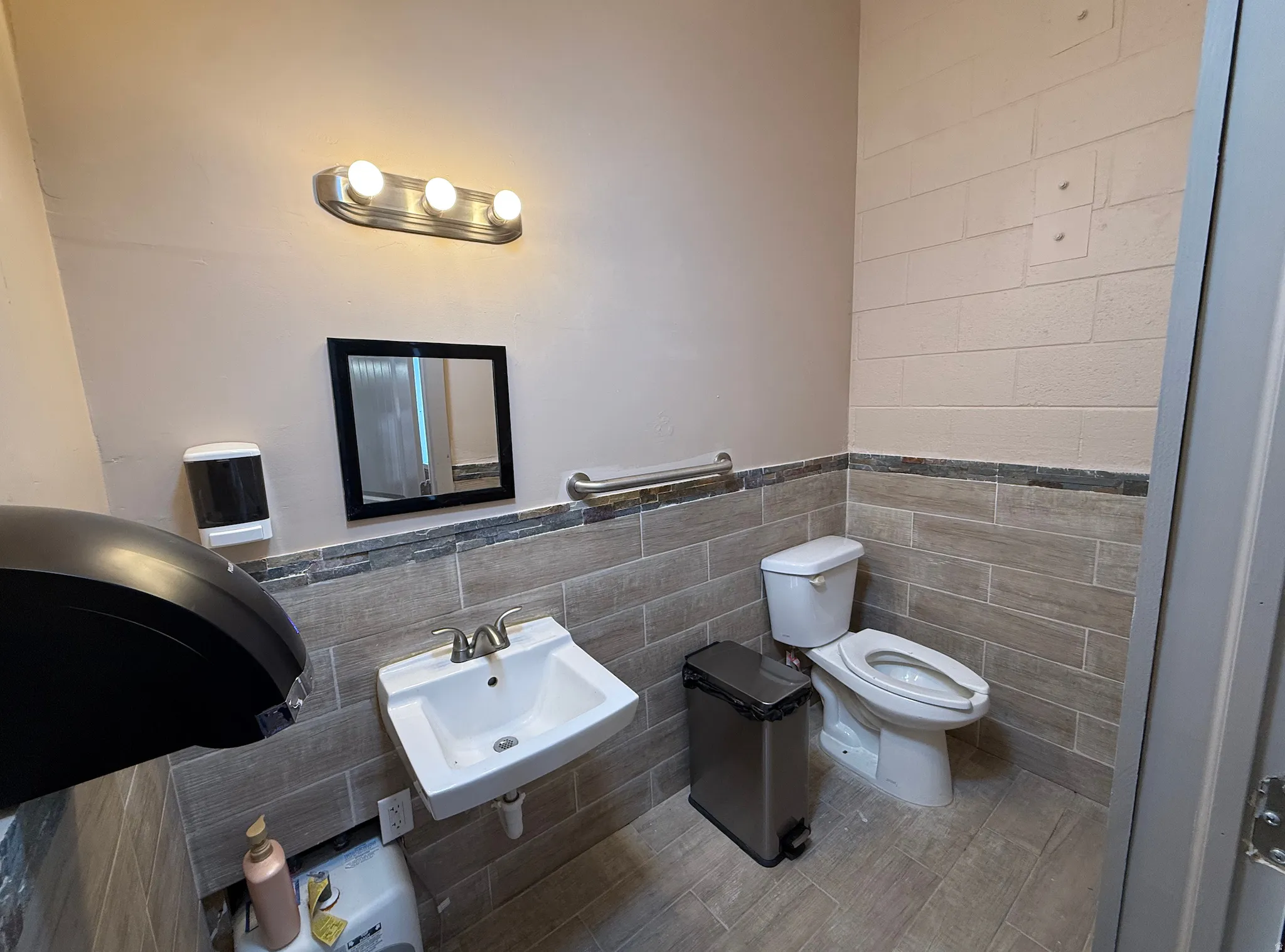 Bathroom with tile walls, wainscoting, and wood finished floors