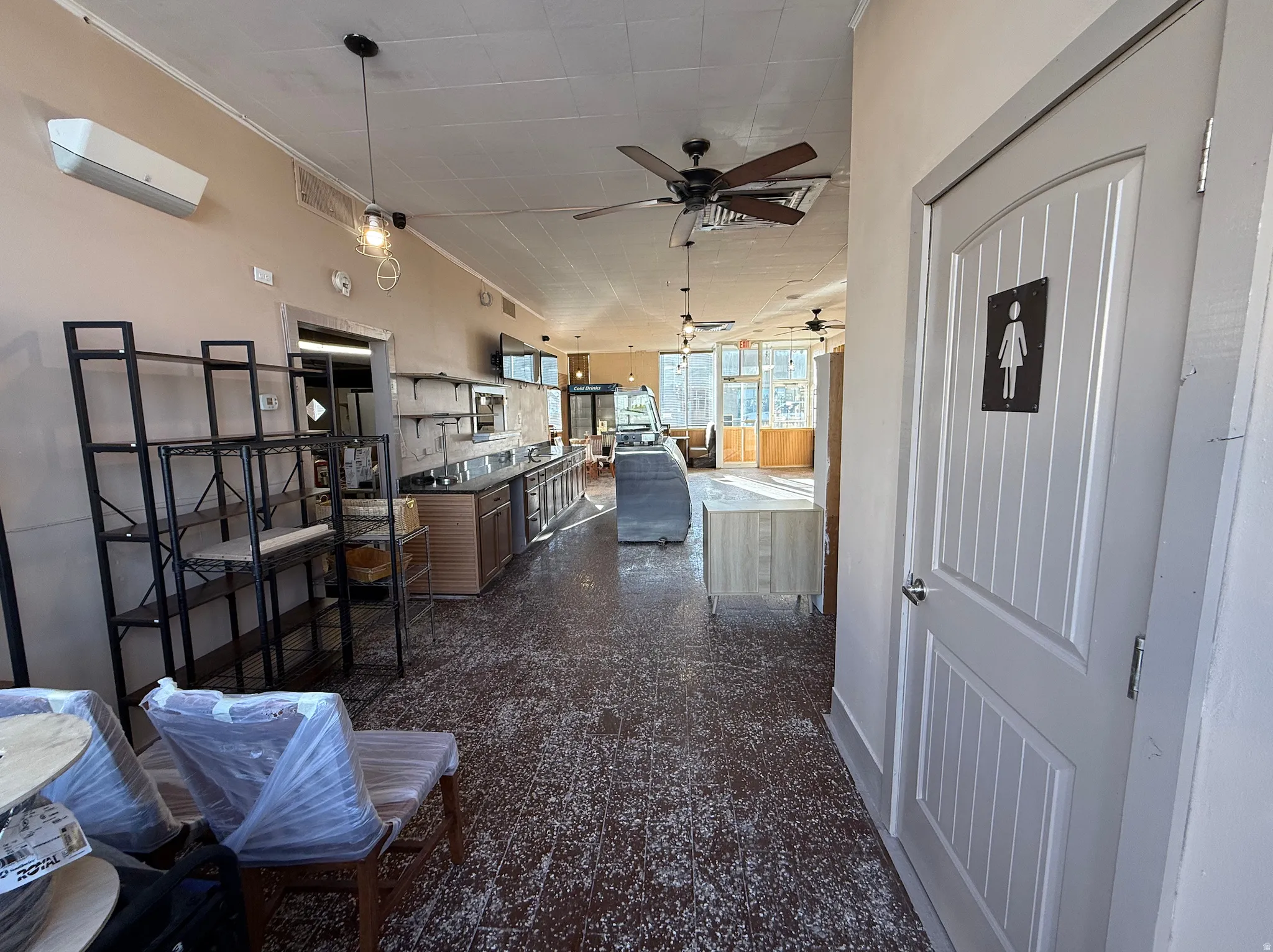 Kitchen with open floor plan, hanging light fixtures, ceiling fan, and a center island