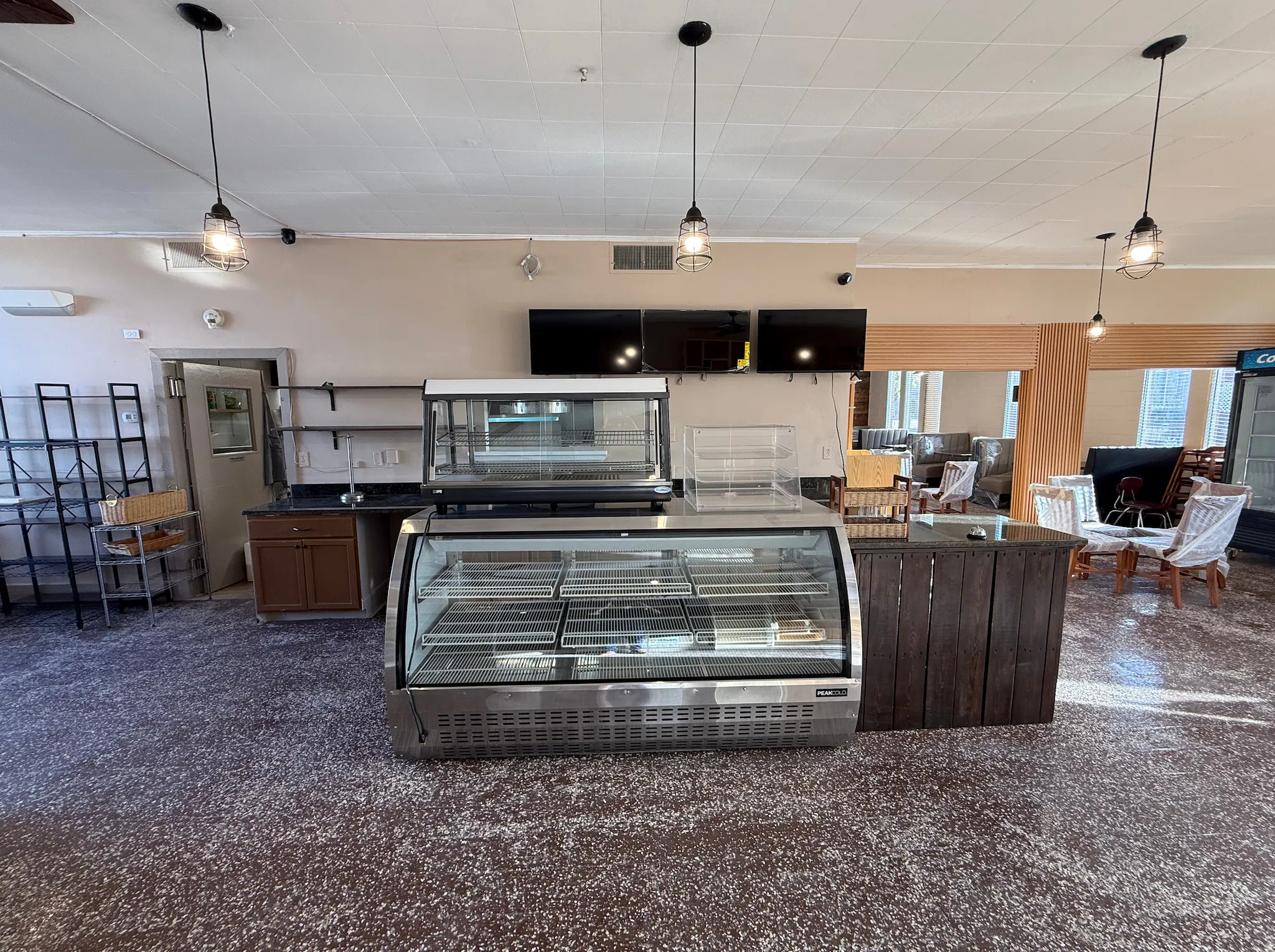 Kitchen with hanging light fixtures, dark wood finish cabinetry, dark stone counters, and open shelves