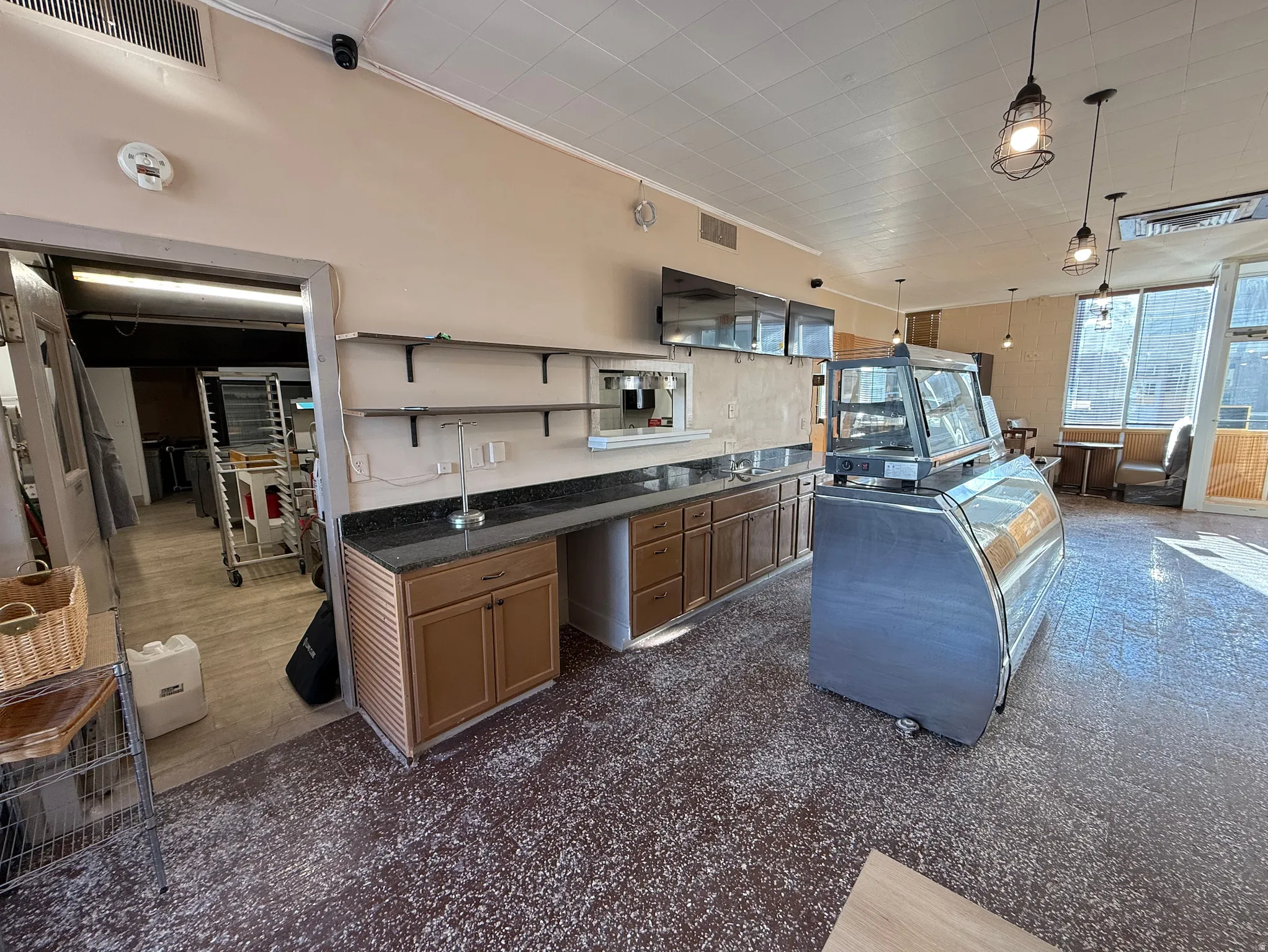 Kitchen with open shelves, hanging light fixtures, and ornamental molding