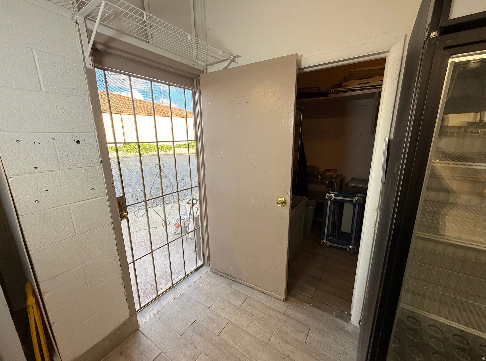 Doorway to outside with concrete block wall and wood finished floors