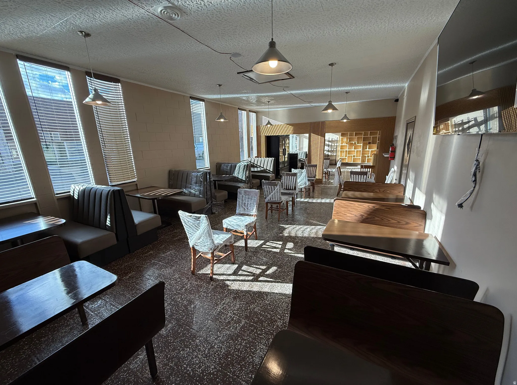 Living area with a textured ceiling, concrete block wall, and granite floors