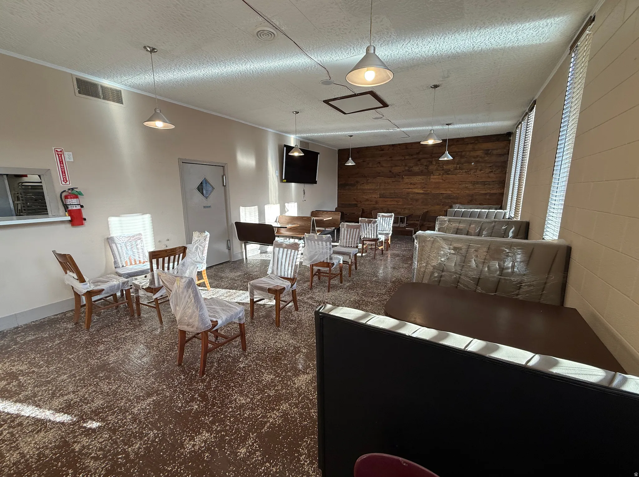 Living area with wooden walls, a textured ceiling, and an accent wall