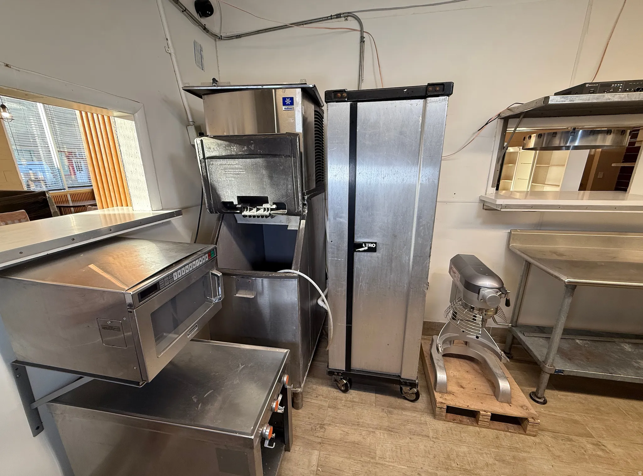 Kitchen featuring light wood-style floors and stainless steel microwave
