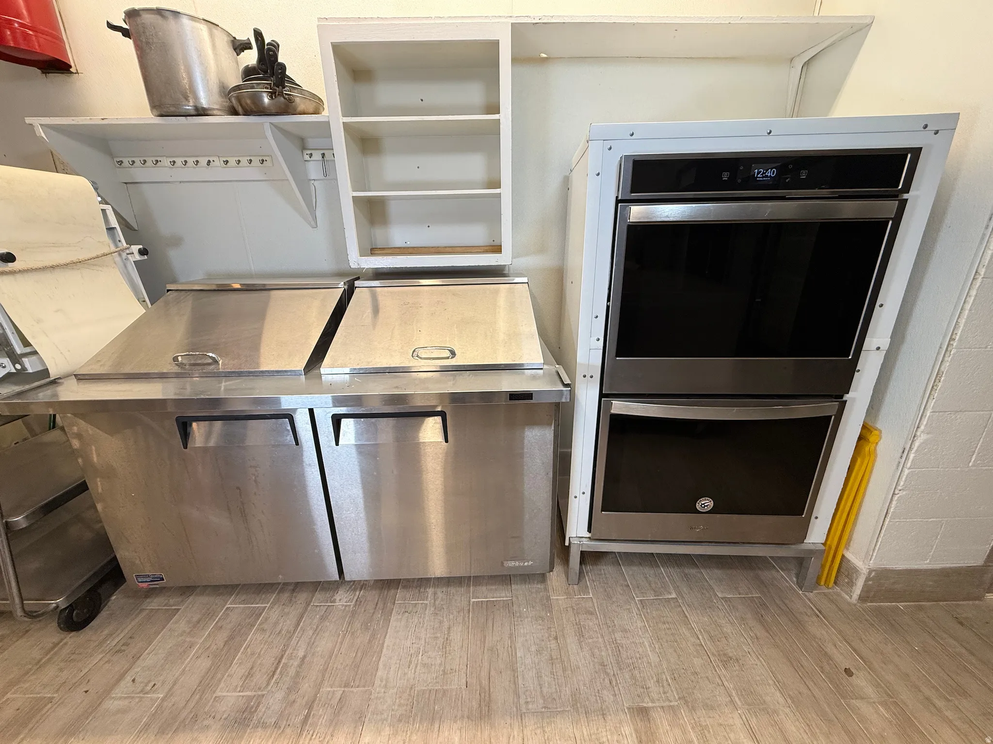 Kitchen with double oven and light wood-style flooring