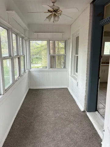 Unfurnished sunroom with a ceiling fan