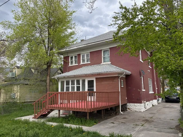 Back of property featuring a wooden deck and a shingled roof