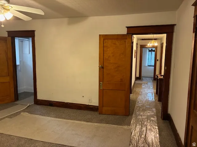 Corridor featuring dark carpet and suspended lighting