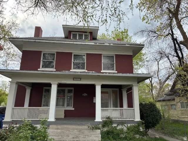 Traditional style home featuring a chimney and a porch