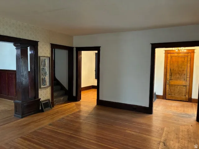 Unfurnished living room with hardwood / wood-style flooring and baseboards