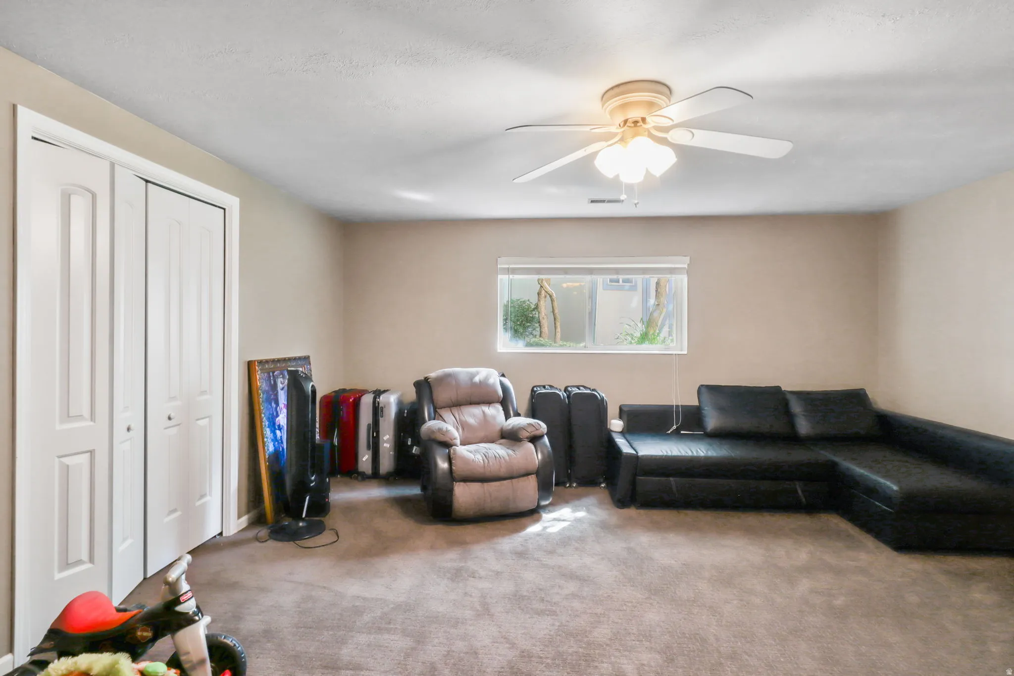 Living room with carpet flooring and a ceiling fan