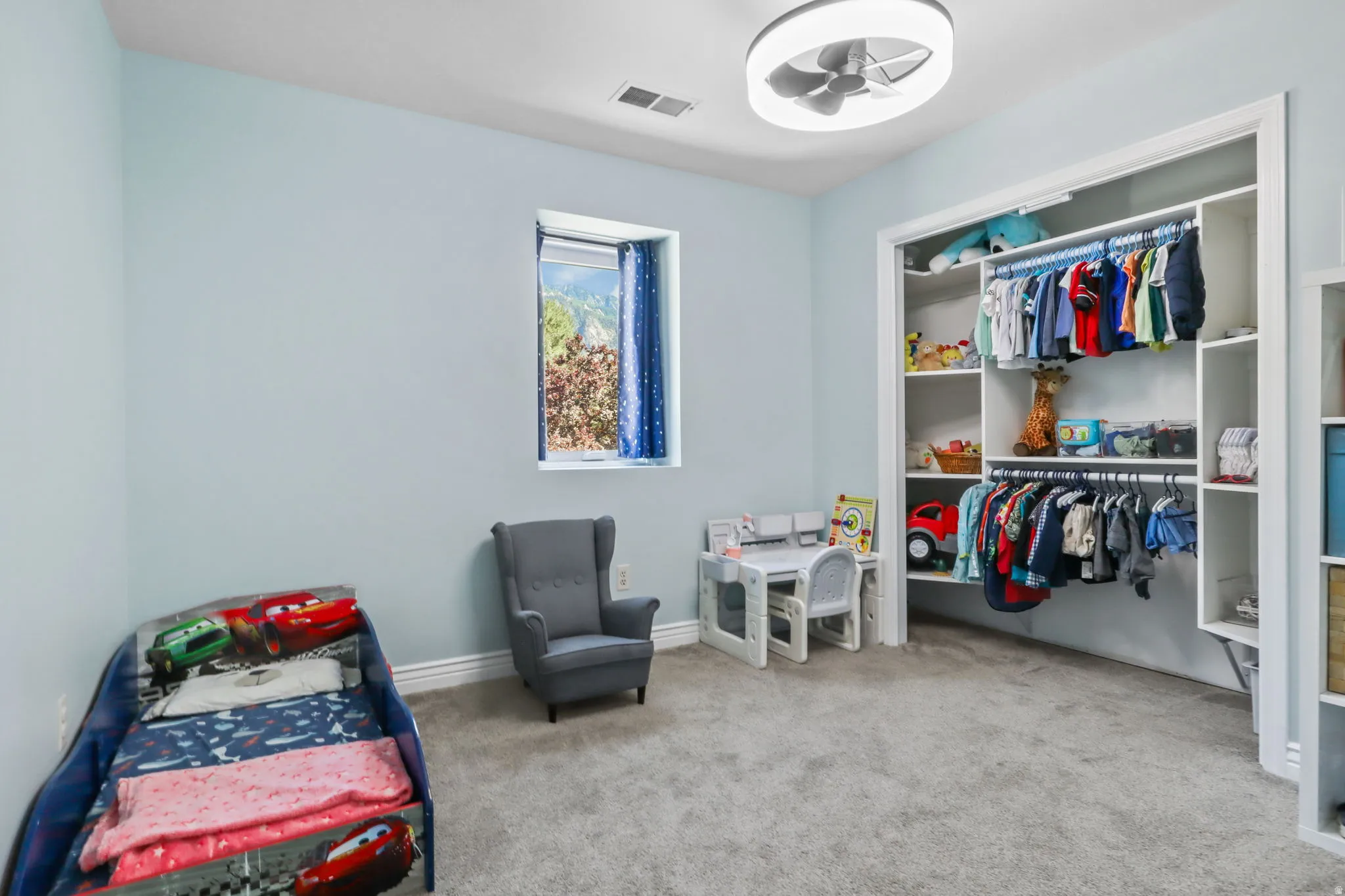 Bedroom with light carpet and a closet
