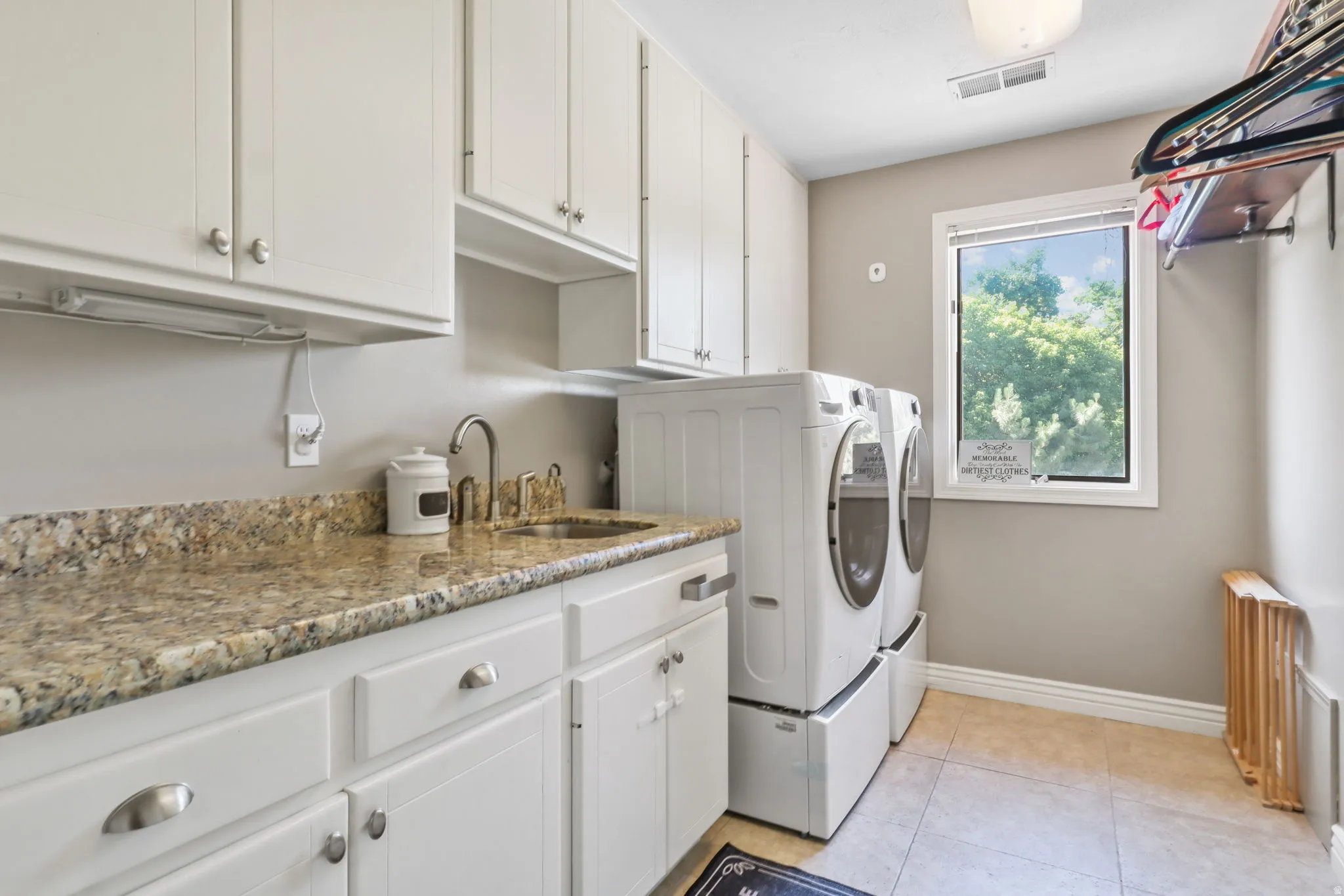 Laundry area featuring cabinet space, washing machine and clothes dryer, and light tile patterned floors