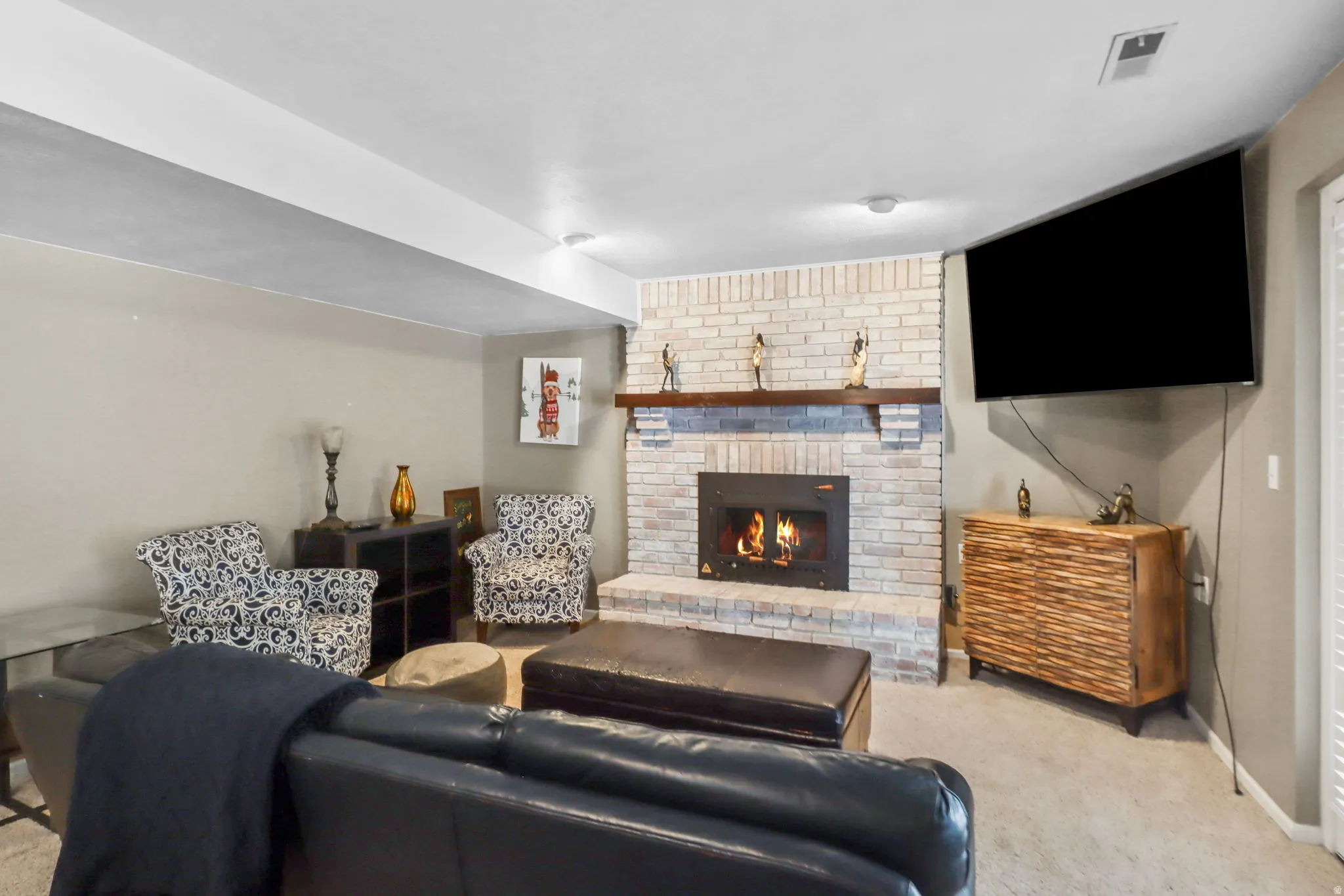 Living area featuring light colored carpet and a brick fireplace