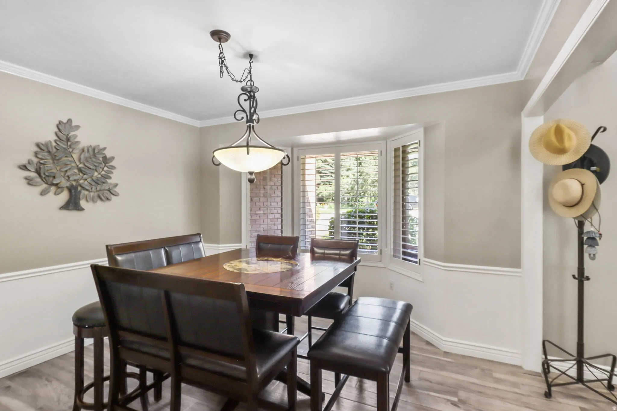 Dining area with wood finished floors and crown molding