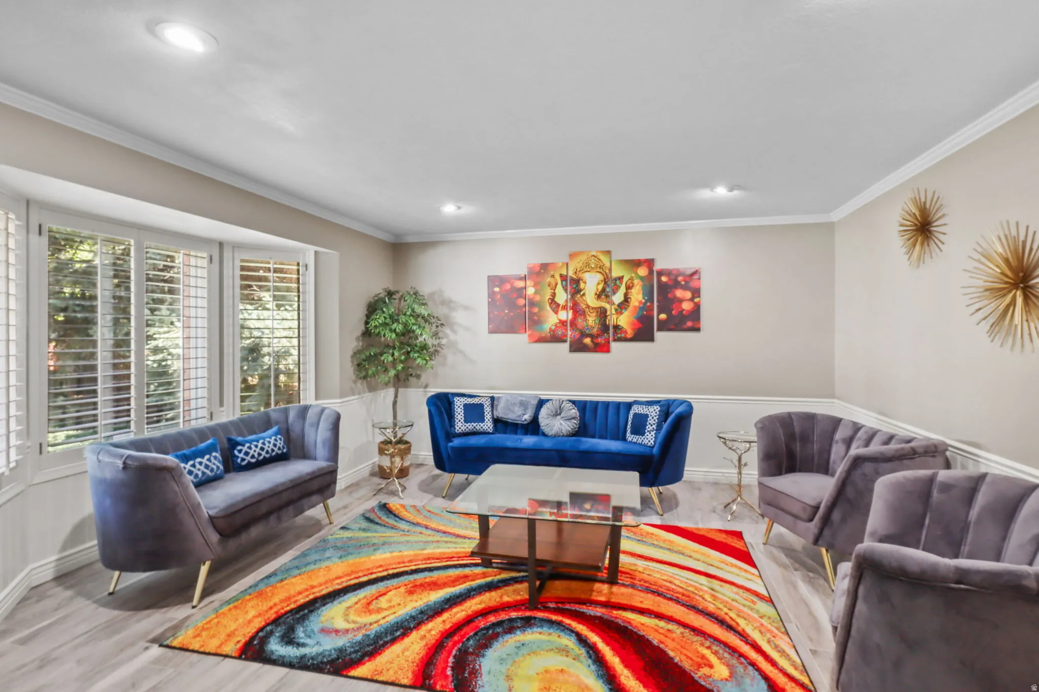 Living room with ornamental molding, a wainscoted wall, light wood-style floors, and recessed lighting
