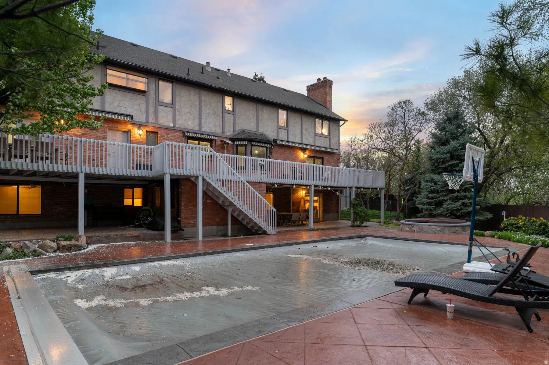Rear view of house featuring a patio, a deck, a swimming pool, and a chimney