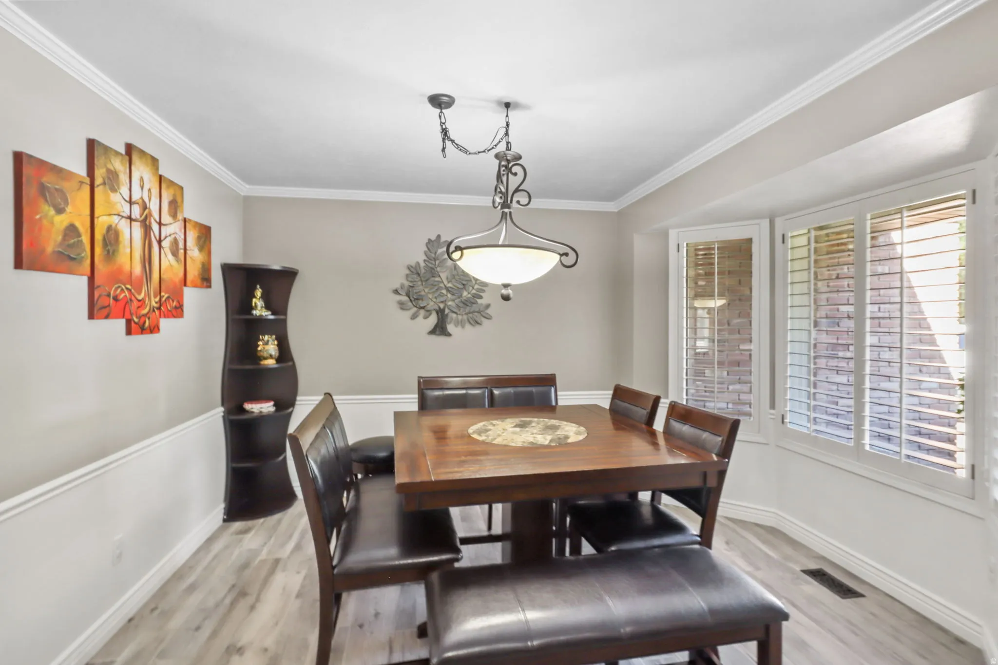 Dining room featuring light wood-type flooring and ornamental molding