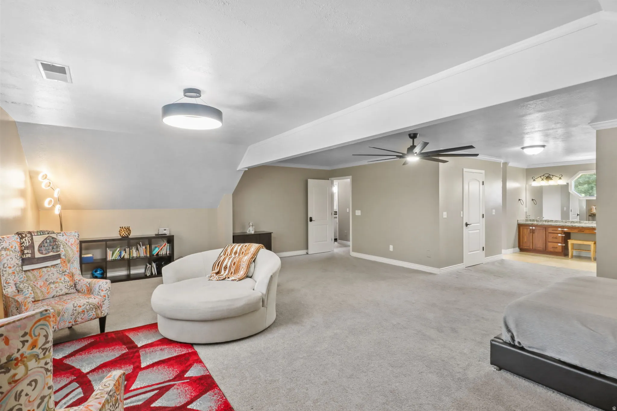 Living area featuring light carpet, a ceiling fan, and ornamental molding