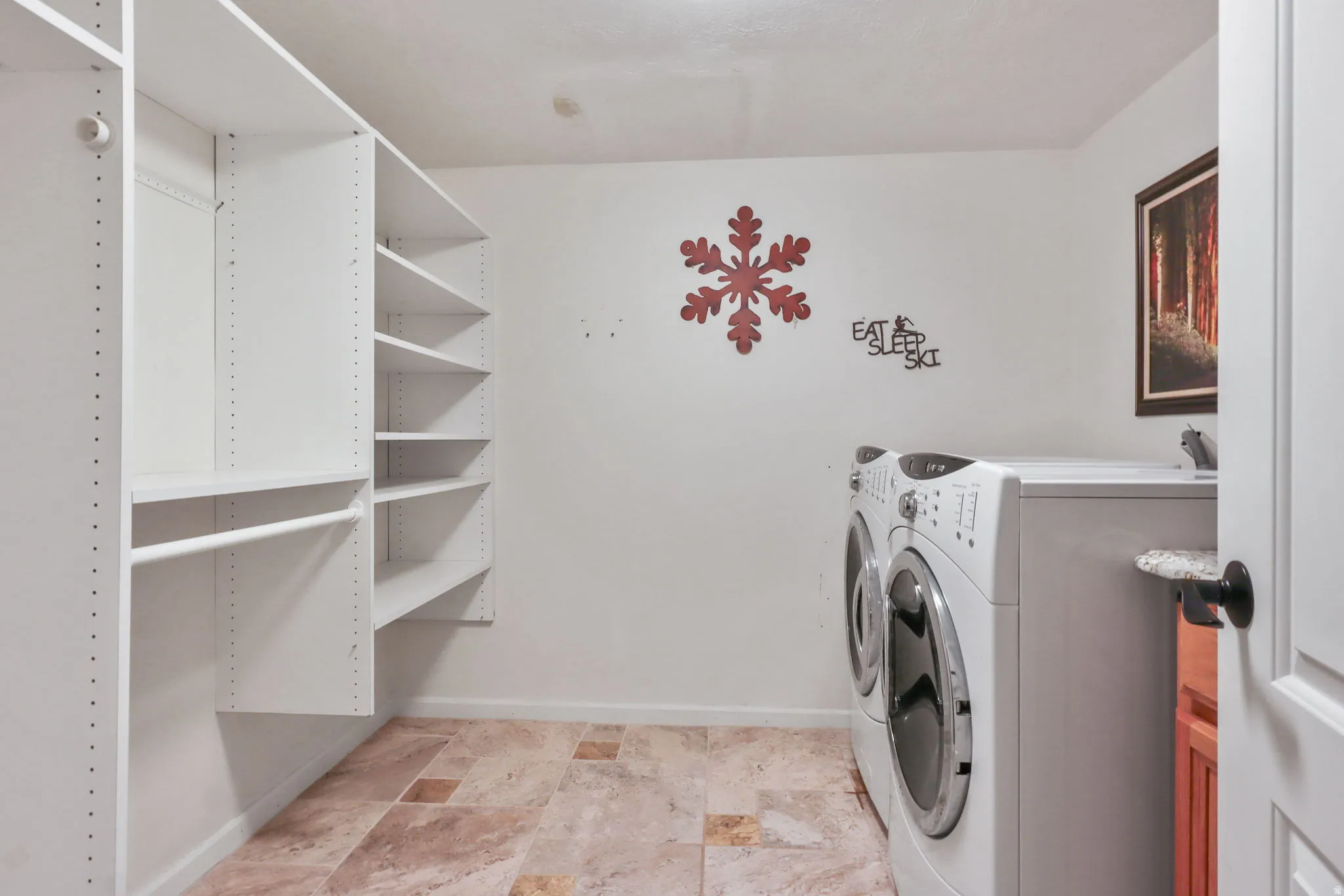 Laundry room featuring washer and dryer and stone finish floors