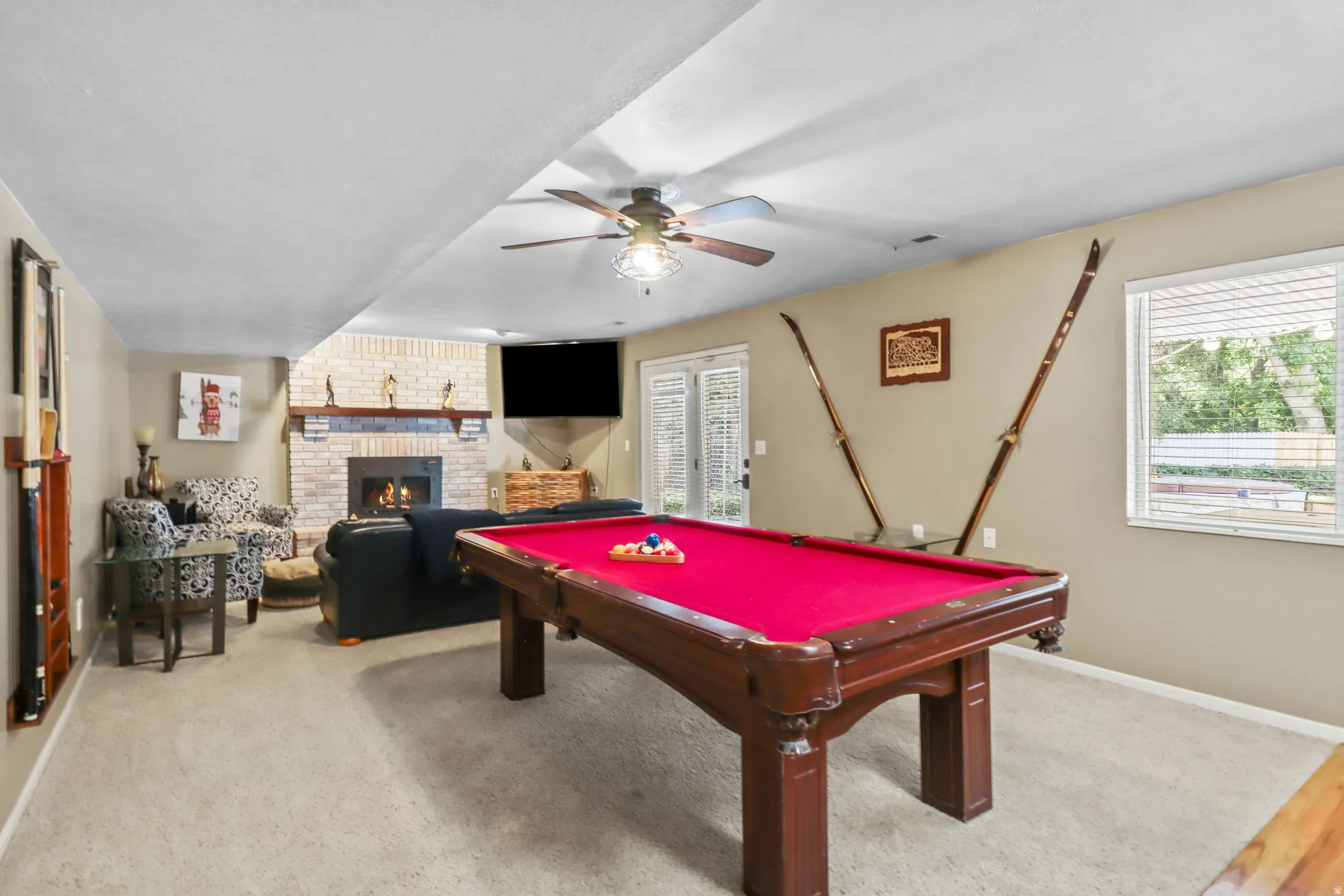 Playroom featuring ceiling fan, a fireplace, billiards table, and light colored carpet
