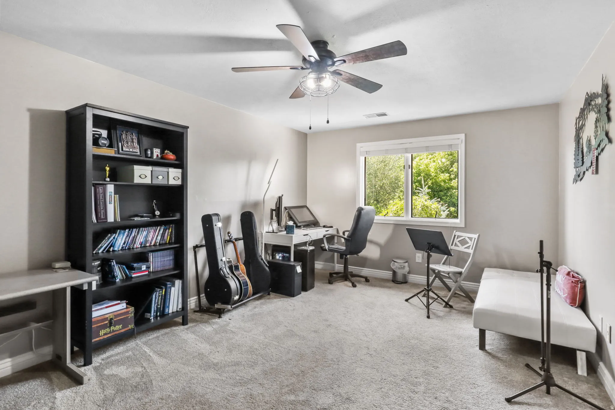 Home office with light colored carpet and ceiling fan