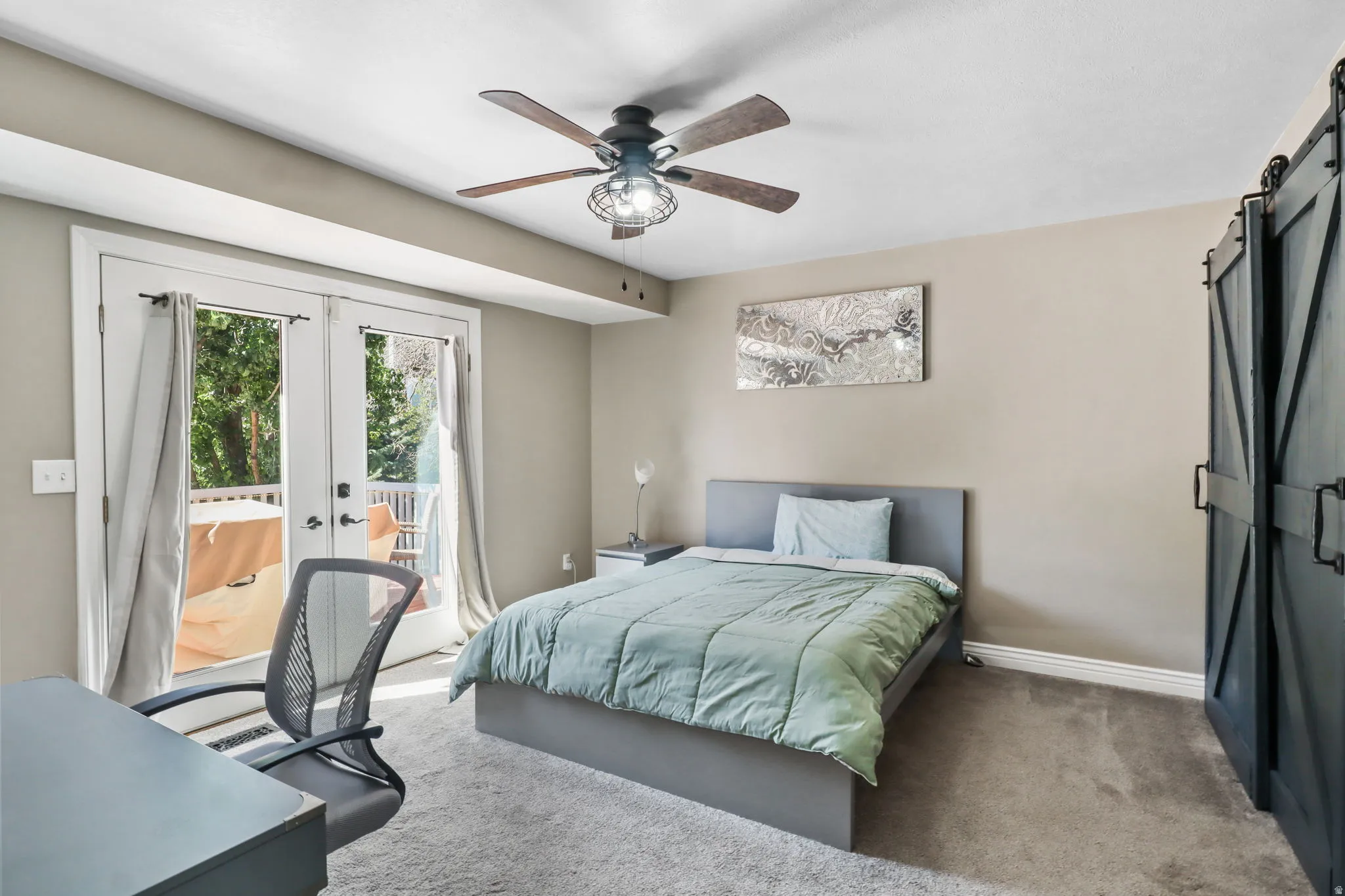 Bedroom featuring a barn door, carpet, access to exterior, and french doors