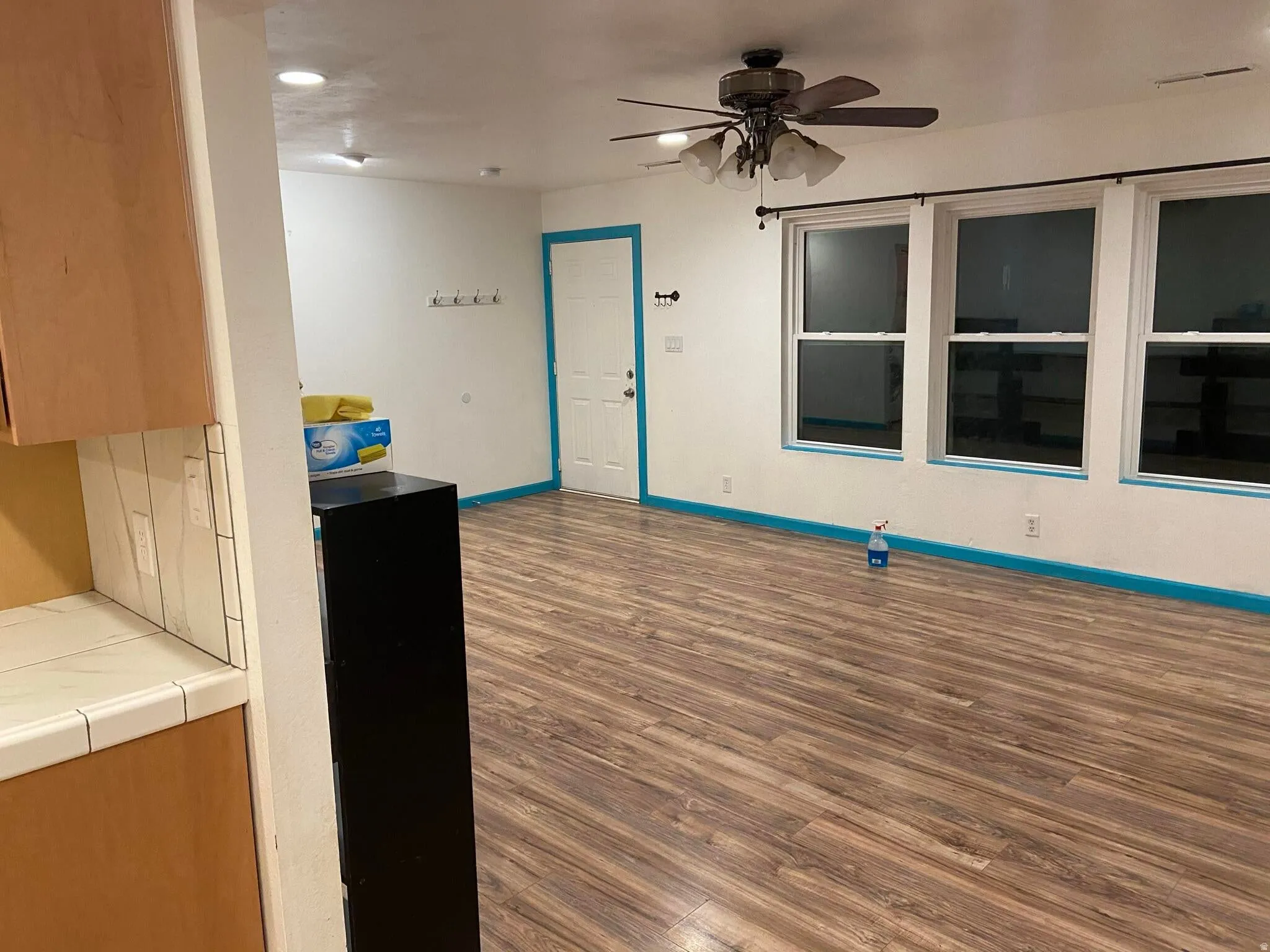 Kitchen featuring dark wood finished floors, ceiling fan, and tile counters
