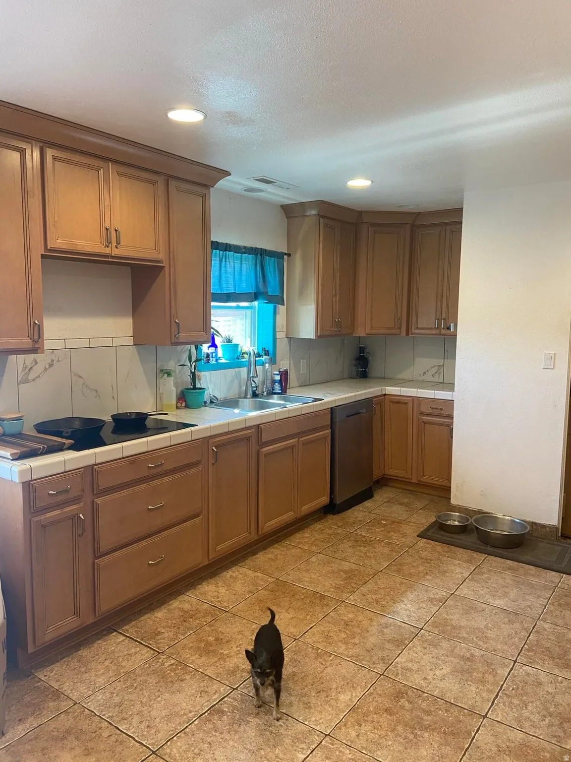 Kitchen featuring tile counters, recessed lighting, wood finish cabinets, tasteful backsplash, and light tile patterned floors