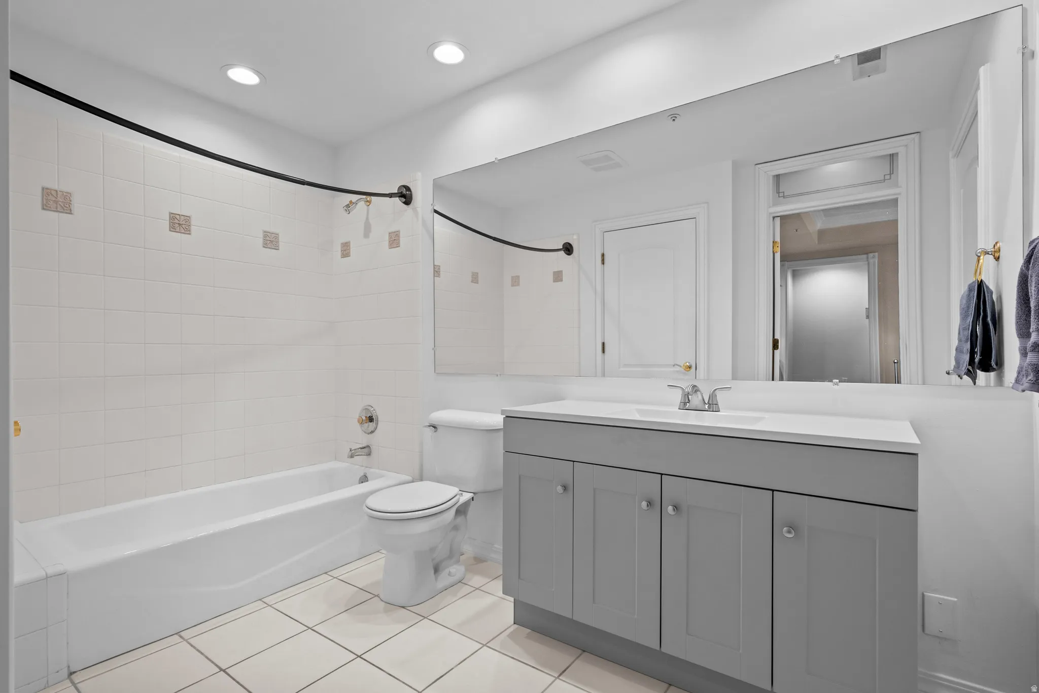Full bath featuring vanity, shower / bath combination, light tile patterned floors, and recessed lighting