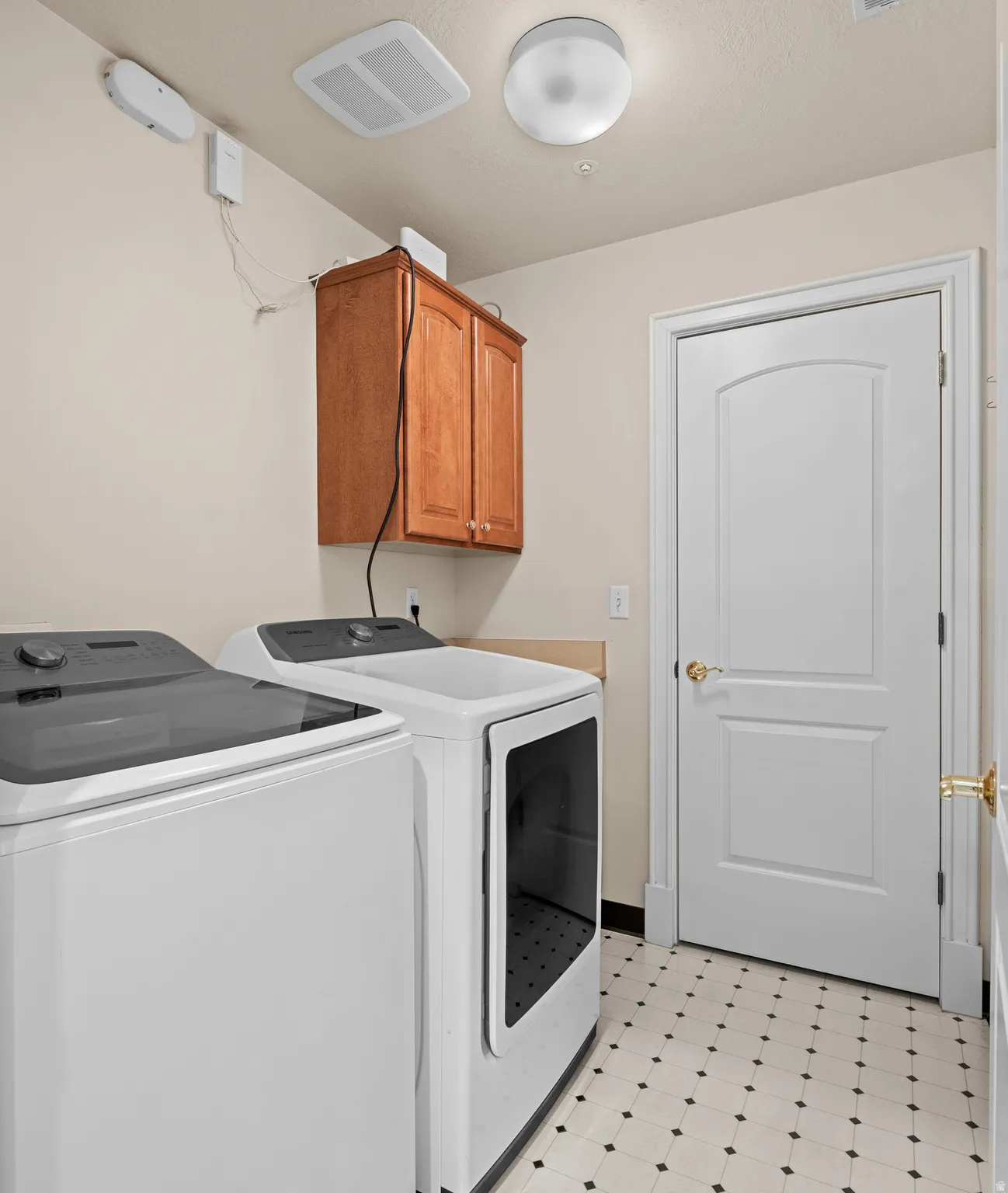 Laundry room with light flooring, cabinet space, and washer and clothes dryer