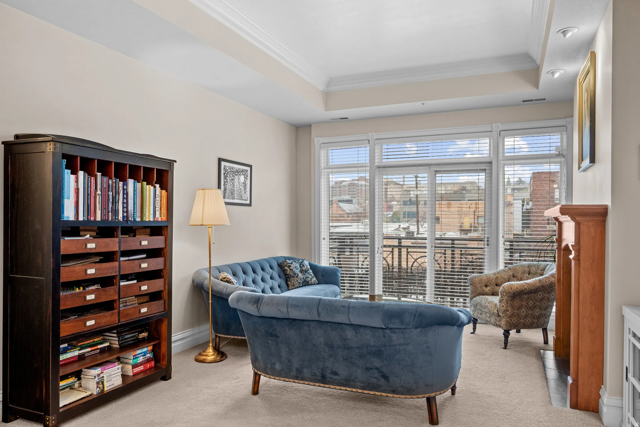 Sitting room with a tray ceiling, ornamental molding, and light colored carpet