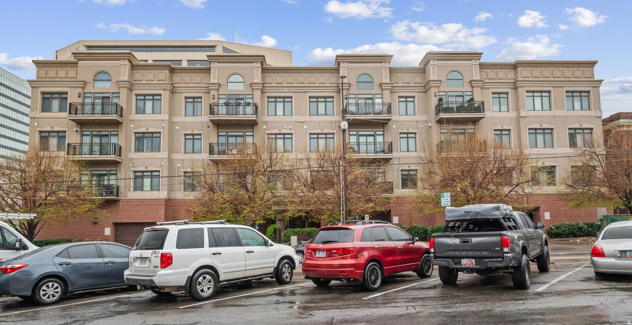 View of apartment building / complex with uncovered parking