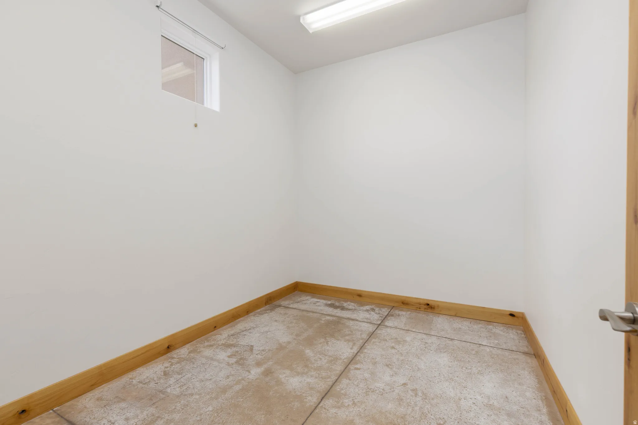 Unfurnished room with concrete flooring and baseboards