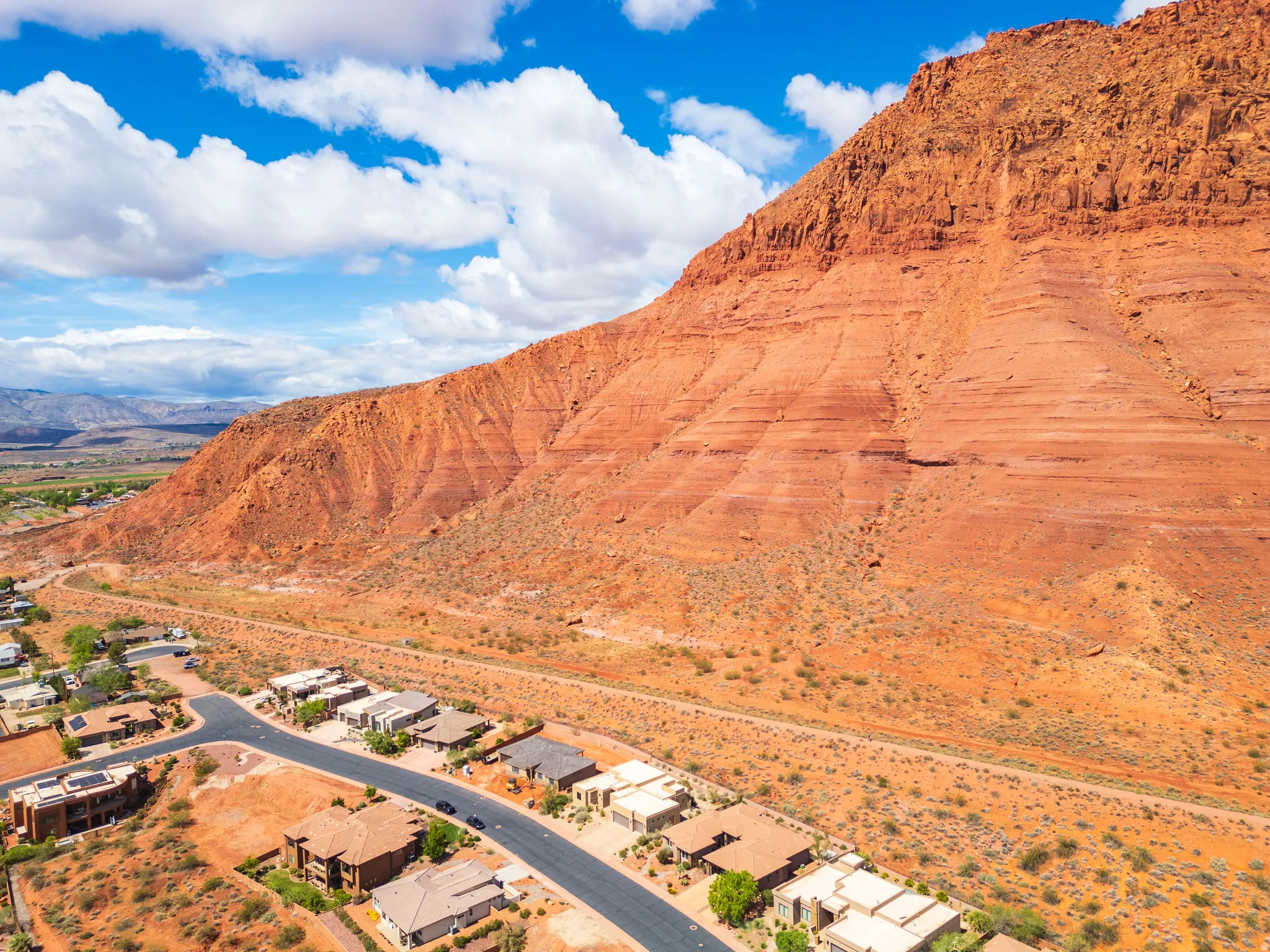Aerial view of sparsely populated area with a mountain backdrop and nearby suburban area