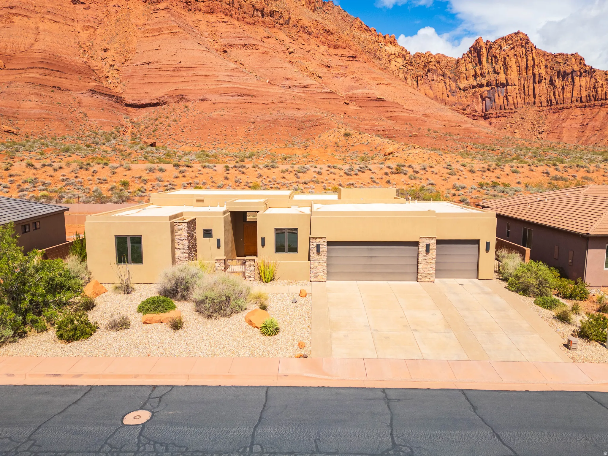 View of front of property with stucco siding, concrete driveway, an attached garage, a desert view, and a mountain view
