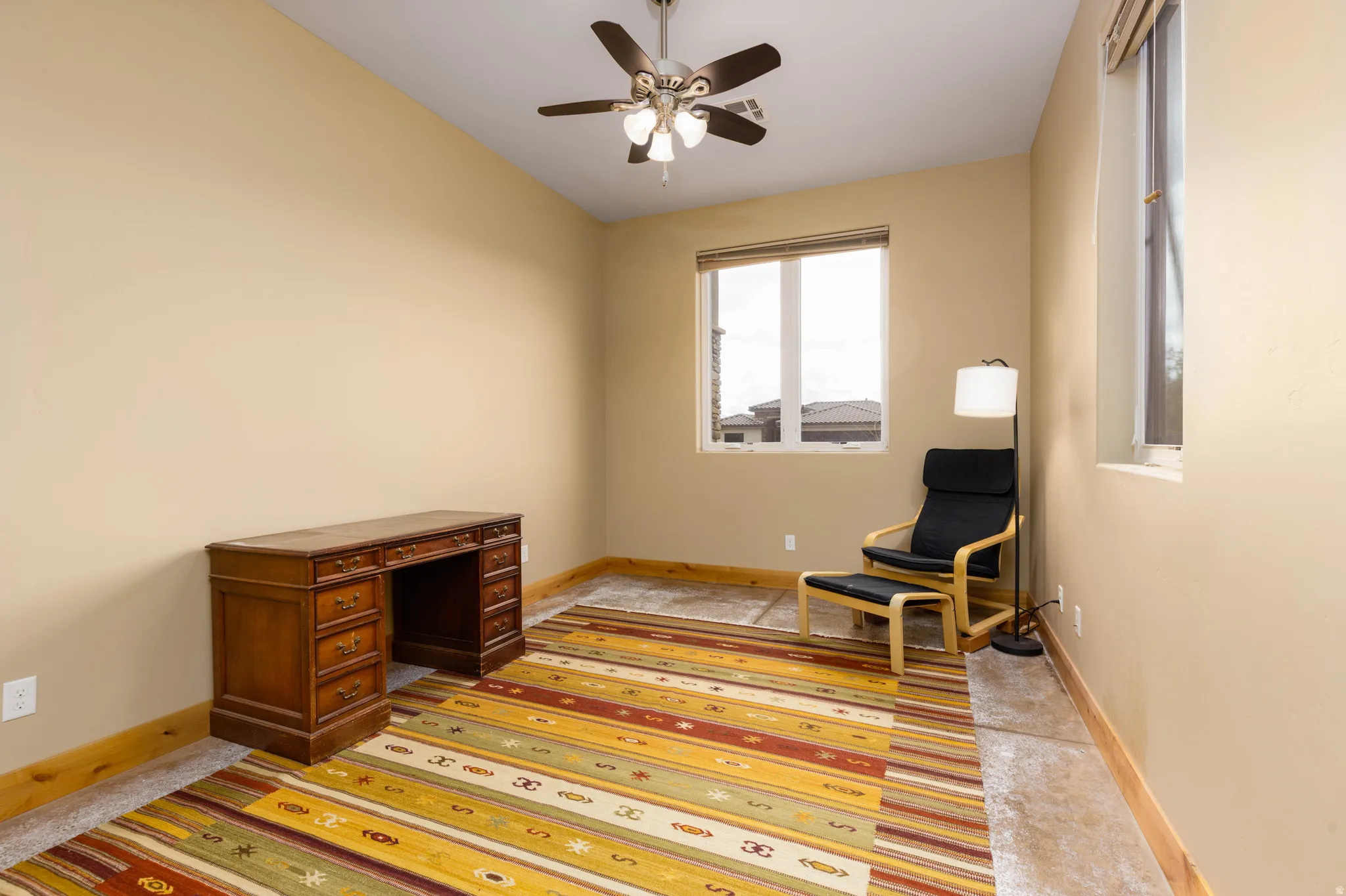 Living area featuring baseboards and a ceiling fan