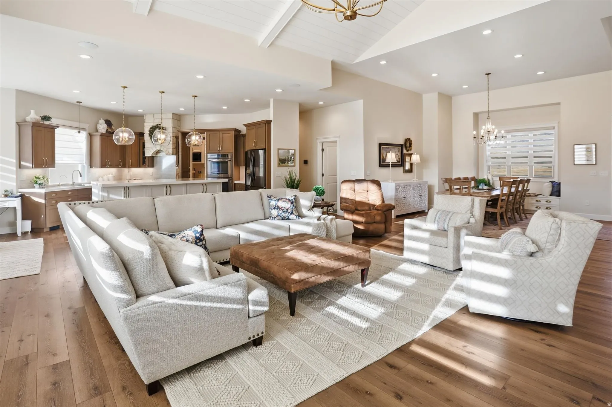 Living area featuring a chandelier, light wood-style floors, and a high wood beamed ceiling