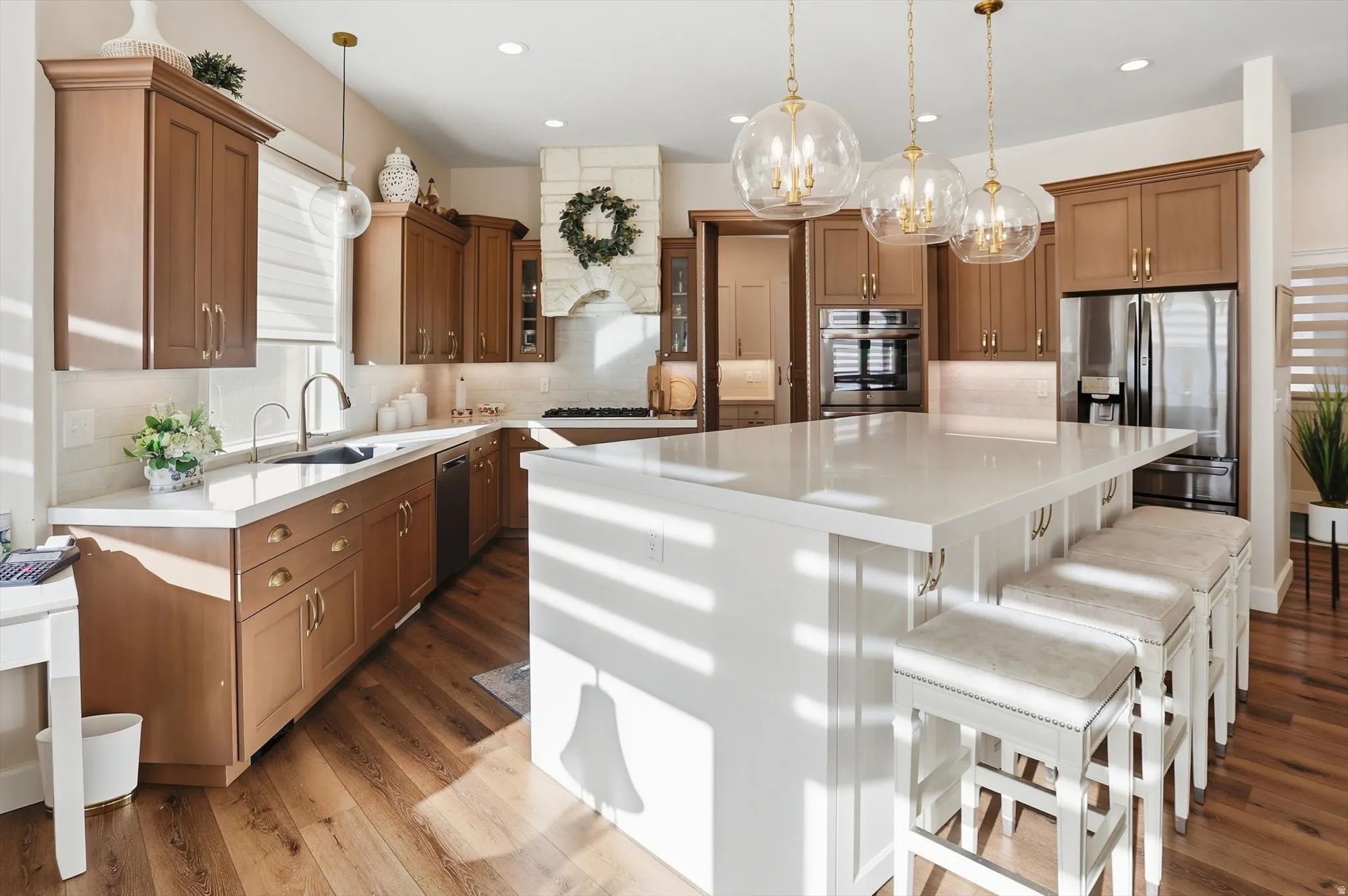 Two tone kitchen with dual tone cabinetry, a large island, stainless steel appliances, backsplash, and a breakfast bar