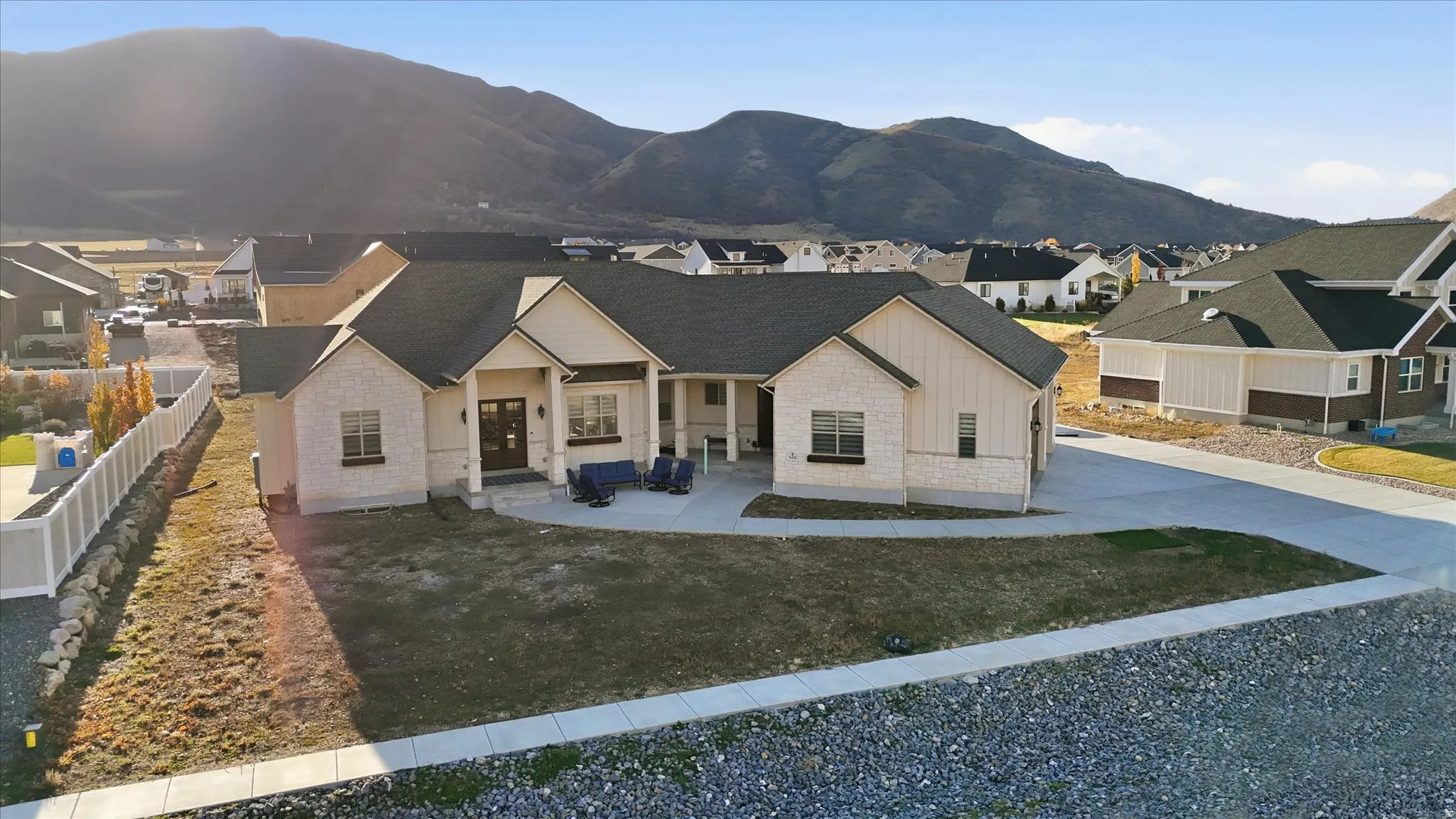 View of front facade with stone siding, a residential view, covered porch, board and batten siding, and a mountain view
