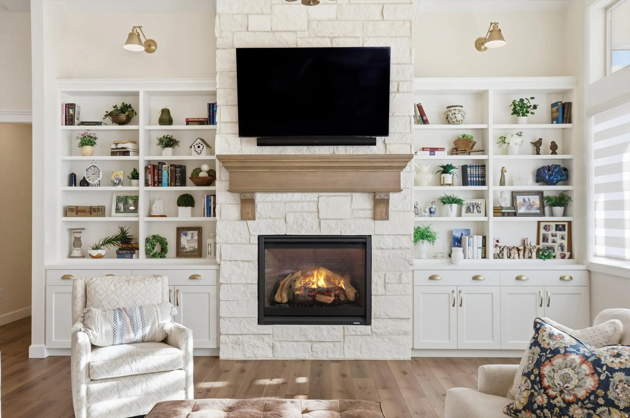 Living room featuring a fireplace, wood finished floors, built in shelves, and plenty of natural light