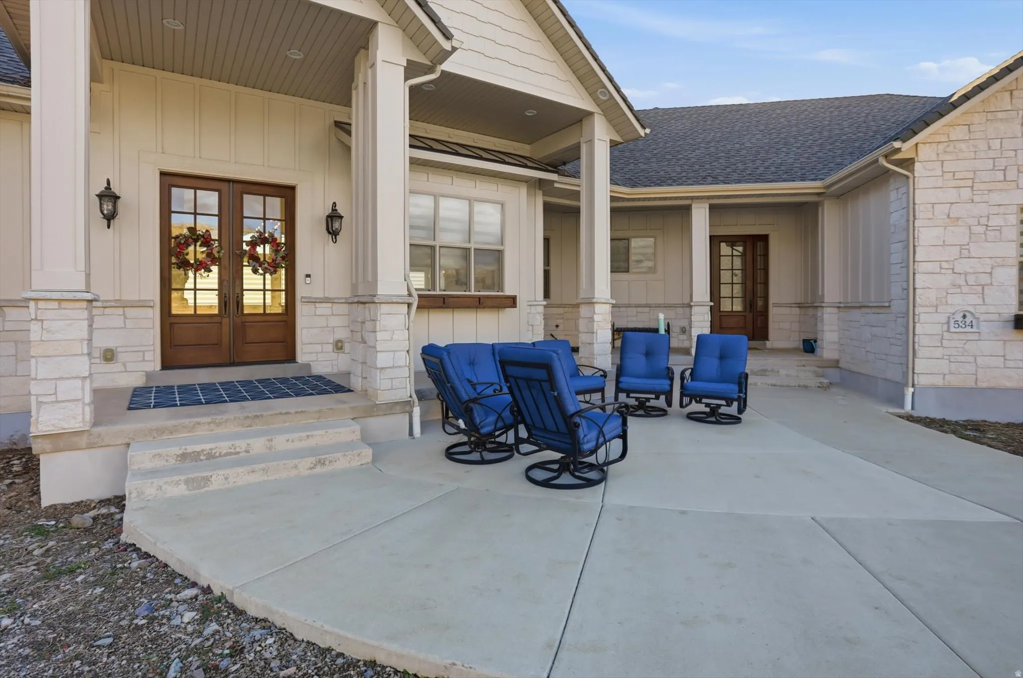 View of exterior entry with french doors, board and batten siding, and roof with shingles