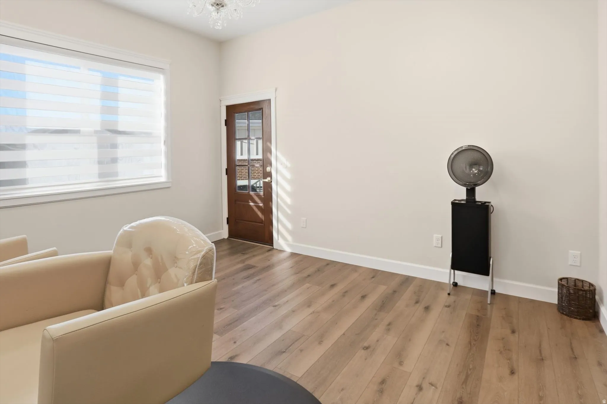 Sitting room with wood finished floors and suspended lighting