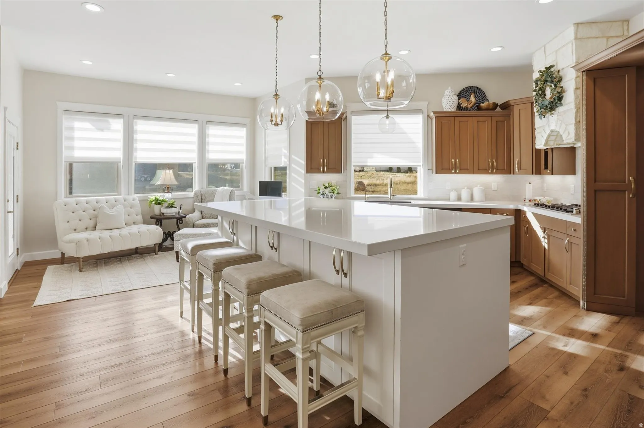 Kitchen featuring wood finish cabinets, a kitchen bar, a center island, light wood finished floors, and light stone counters