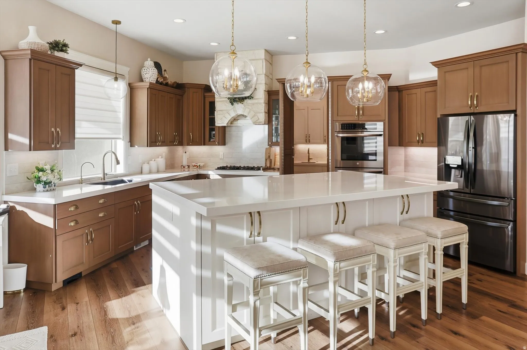 Kitchen featuring a kitchen breakfast bar, two tone cabinets, stainless steel appliances, a kitchen island, and backsplash