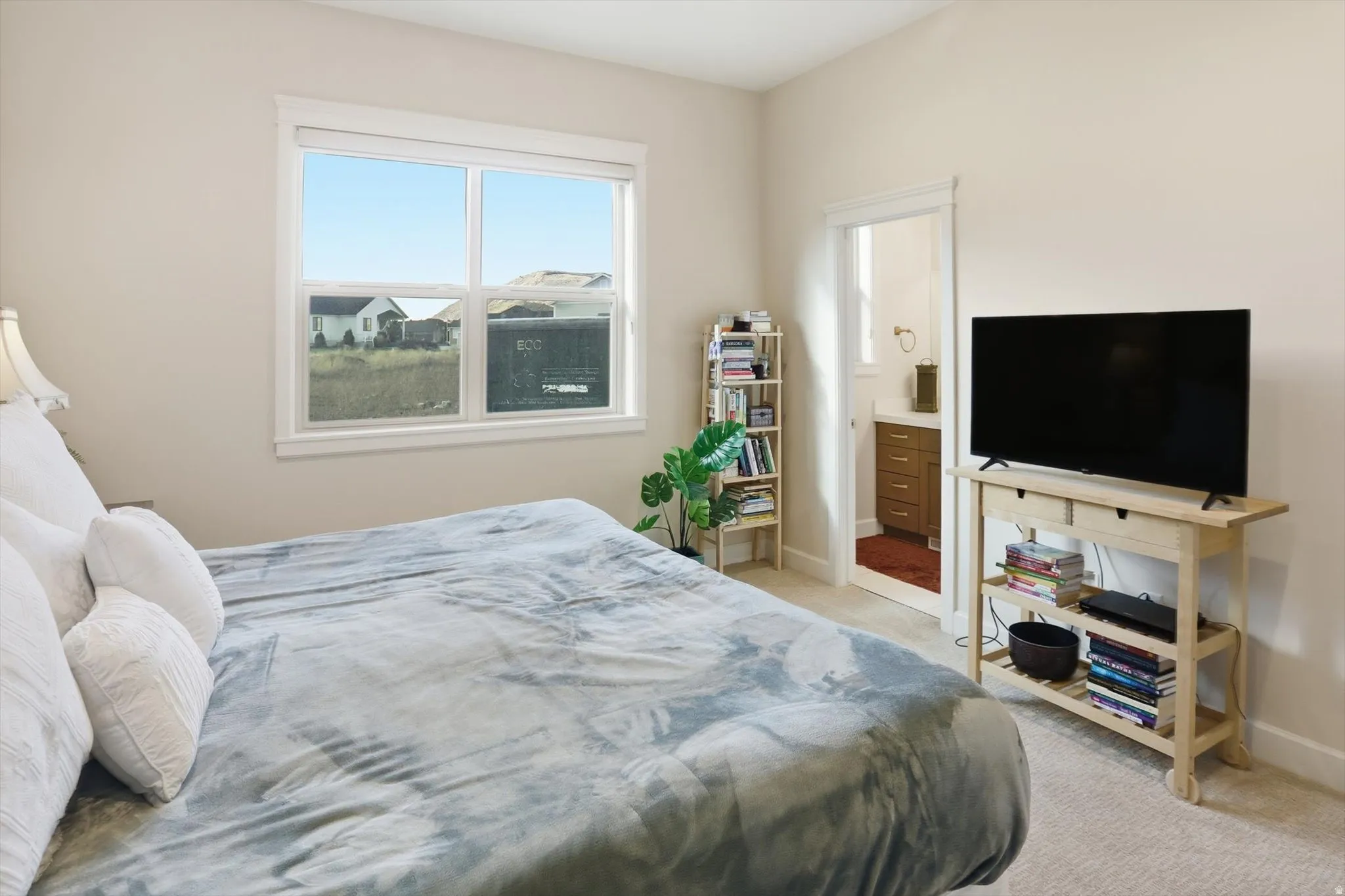 Bedroom featuring light carpet and connected bathroom