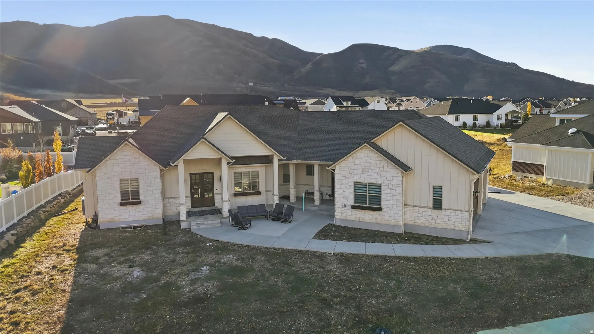 View of front of home featuring board and batten siding, stone siding, and covered porch