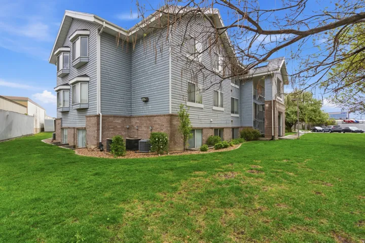 View of side of property with a yard and brick siding