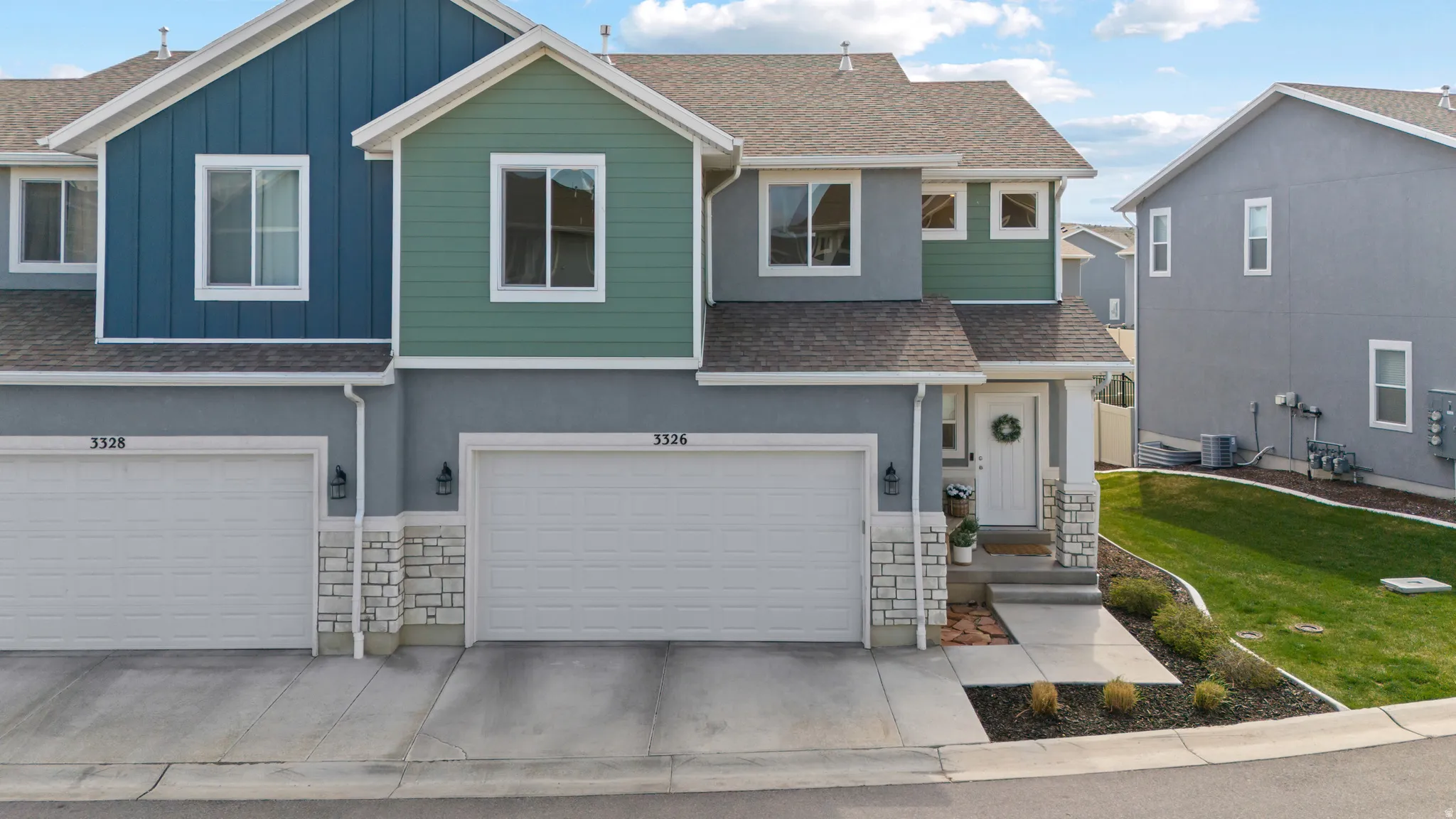 View of front of property with a shingled roof, stone siding, board and batten siding, and an attached garage