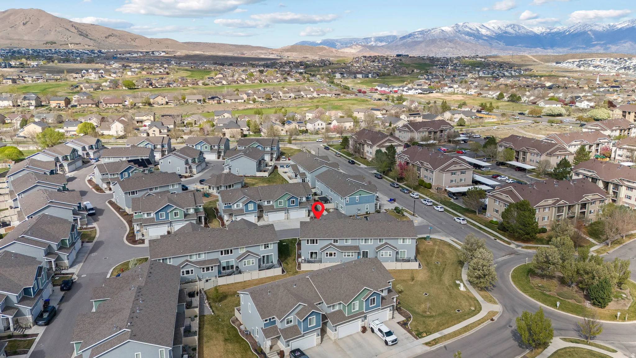 Aerial view of property and surrounding area with mountains and nearby suburban area